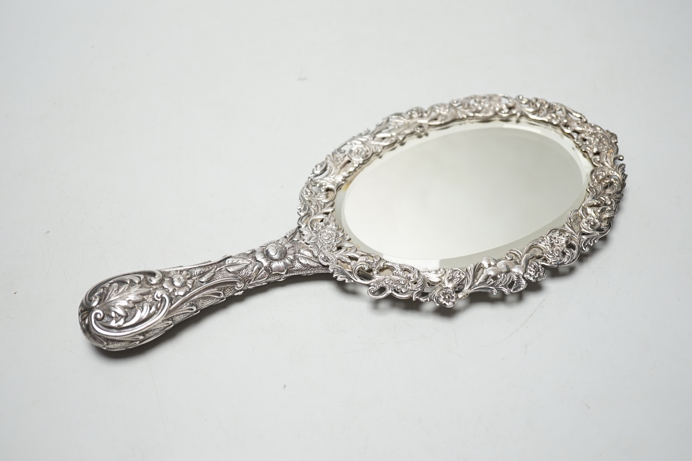 A late Victorian embossed silver hand mirror, Samuel Walton Smith, Birmingham, 1891, 27cm.